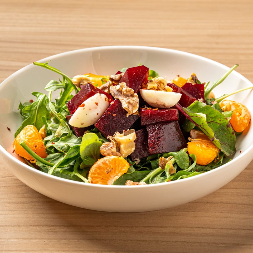 Nour's Lebanese salad with beets, walnuts, mandarin oranges, and hard-boiled eggs on a bed of greens.