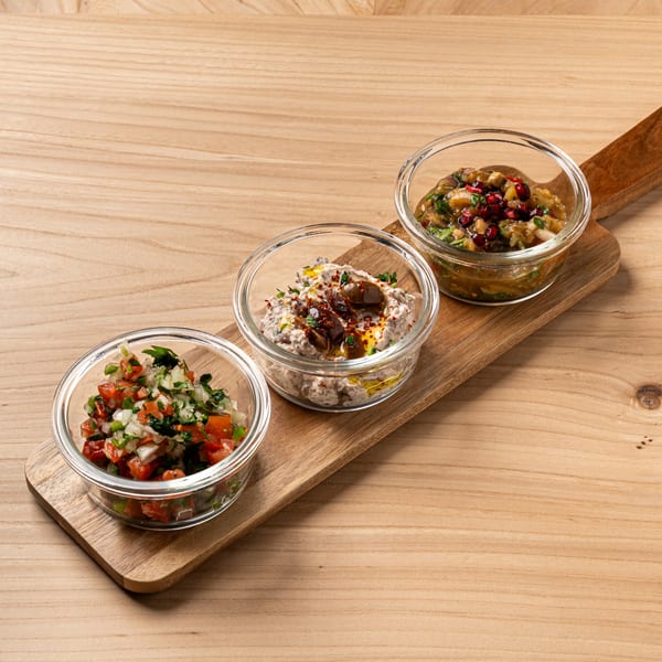 Three Lebanese mezze dips: salsa, baba ghanoush, and another eggplant dip with pomegranate seeds.